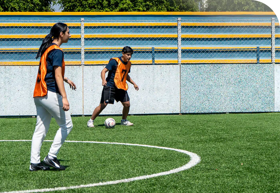 Estudiantes jugando futbol en las canchas del campus